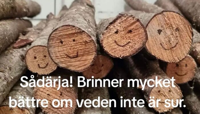 Staplad ved med ritade smilies på ändträet och texten "Sådärja! Brinner mycket bättre om veden inte är sur.