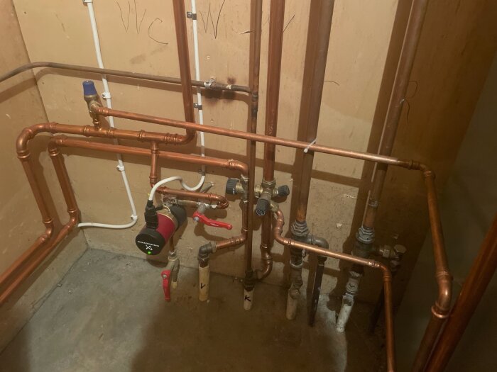 Isolerade kopparrör kopplade till VVC-system och Shelly-enhet i en källarinstallation.