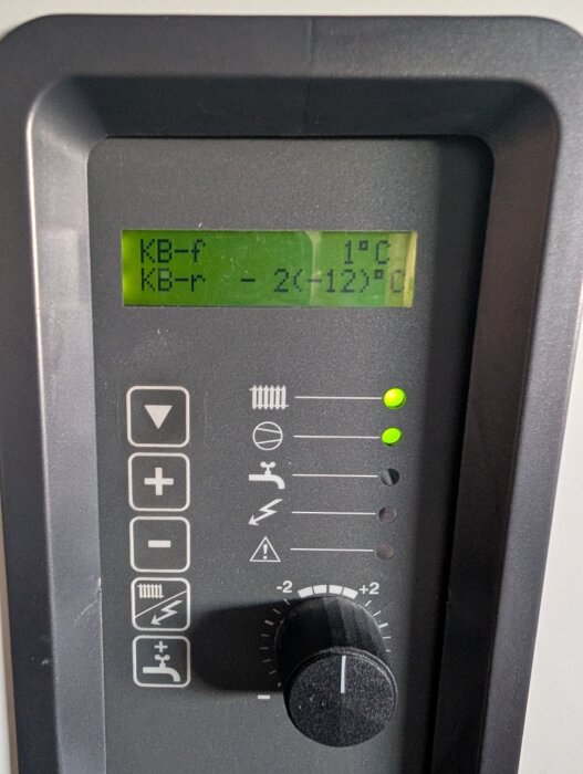 Display på värmepump som visar temperaturer; KB-f 1°C, KB-r -2°C, med vred för justering och indikatorlampor.