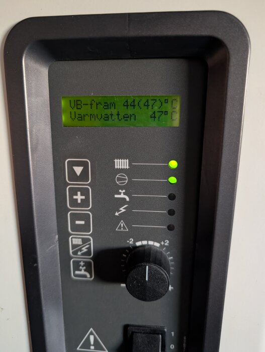 Display på värmepump visar VB-fram 44°C (47°C) och varmvatten 47°C med kontrollknappar och ratt för justering.