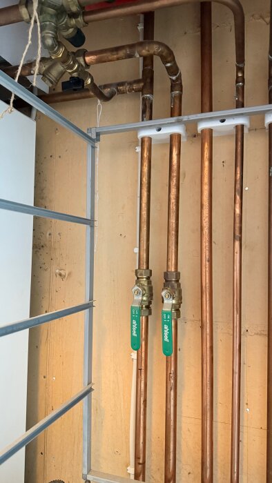Kopparrör med ventiler installerade mot en vägg, del av ett värmesystem kopplat till en Nibe Fighter 1225 värmepump.