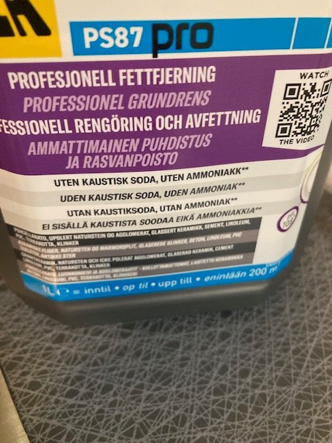 Flaska med professionell fettlösning och avfettning, märkt PS87 pro, på klinkergolv; utan kaustiksoda och ammoniak.