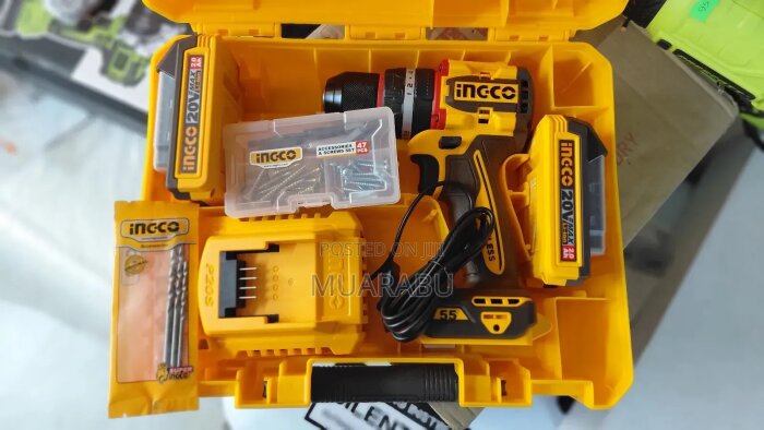 En Ingco batteridriven slagborrmaskin med tillbehör inklusive borr, bits och laddare, presenterad i en gul förvaringslåda.