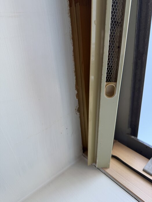 Närbild av ett takfönster med synlig ventilation och trä under, potentiellt indikerande fuktproblem på grund av dålig tätning.
