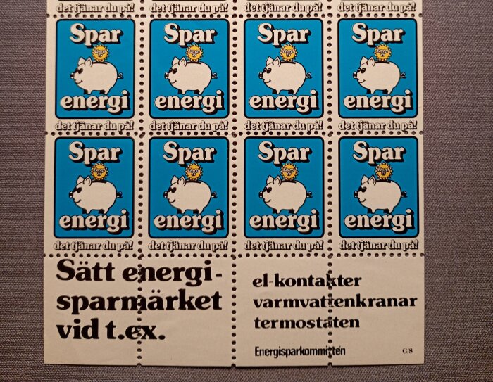 Åtta blå energisparmärken med en vit gris och texten "Spar energi". Mellan märkena står det "Sätt energisparmärket vid t.ex. el-kontakter".