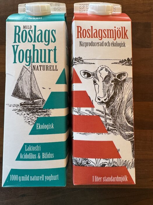 Förpackningar av Roslags Yoghurt Naturell och Roslagsmjölk, ekologiska och närproducerade, med illustrationer av en segelbåt och en ko.