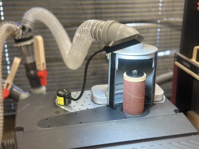 Kombinerad band/spindel-slip med spånsug, magnetisk lampa och justerad sughuv för bättre dammhantering.