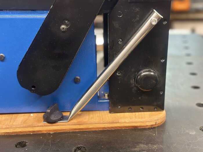 Scheppach bandslip BTS900 på monterad träbas, med justerbar metallarm och svart plasthölje.