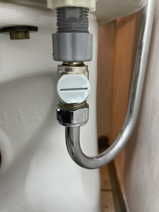 Inloppsventil och anslutning till toalett med tecken på vattenläckage.