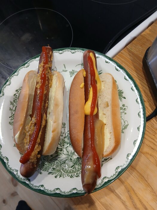 Två hot dogs på en tallrik, toppade med ketchup och olika typer av senap.