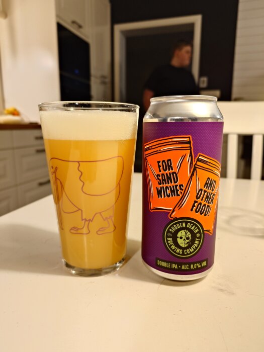 Ett glas ljus öl och en burk med etiketten "Sudden Death Brewing Company, Double IPA, 8.0% vol" i ett kök.