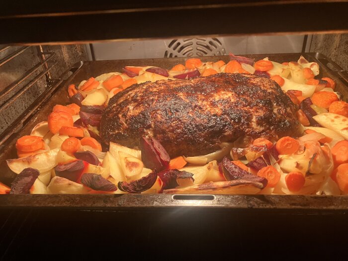 Stek i ugn med rotfrukter som morötter, potatis, rödbetor och lök, omgiven av en gyllene och krispig skorpa.
