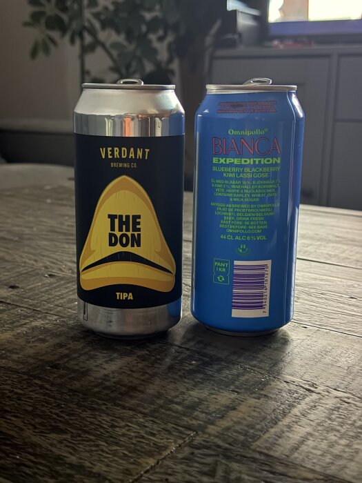 Två ölburkar på ett bord, en från Verdant Brewing Co. "The Don" och en från Omnipollo "Bianca Expedition".