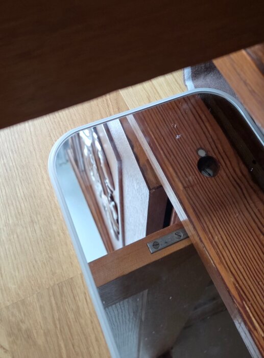 Spegelbild av dolda gångjärn skruvade underifrån på sidan av en trälucka.