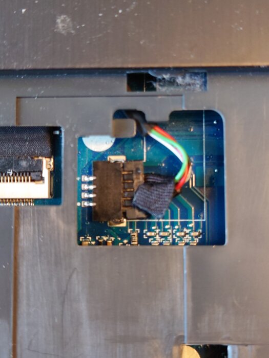 Elektronisk komponent med flera färgade kablar anslutna; fråga om hur dessa kontakter demonteras.