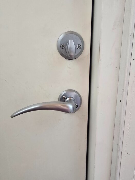 Dörr med ett Assa 410 låshus över ett handtag. Låset är vridbart 360 grader.