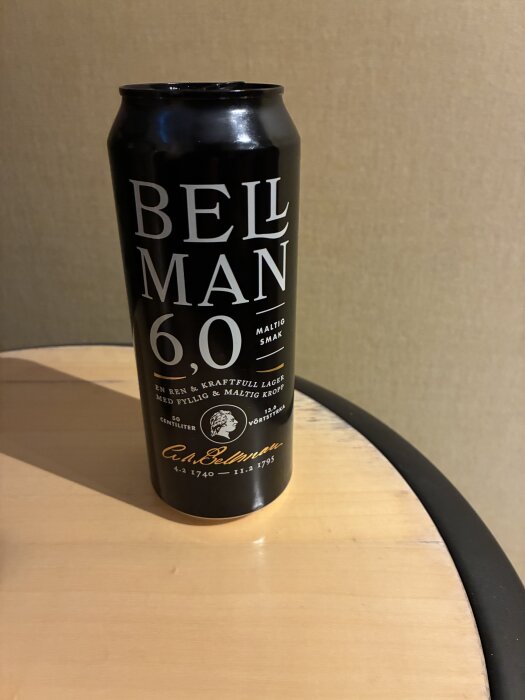 En svartöl Bellman 6.0 burk står på ett bord med text om maltig smak och alkoholhalt.