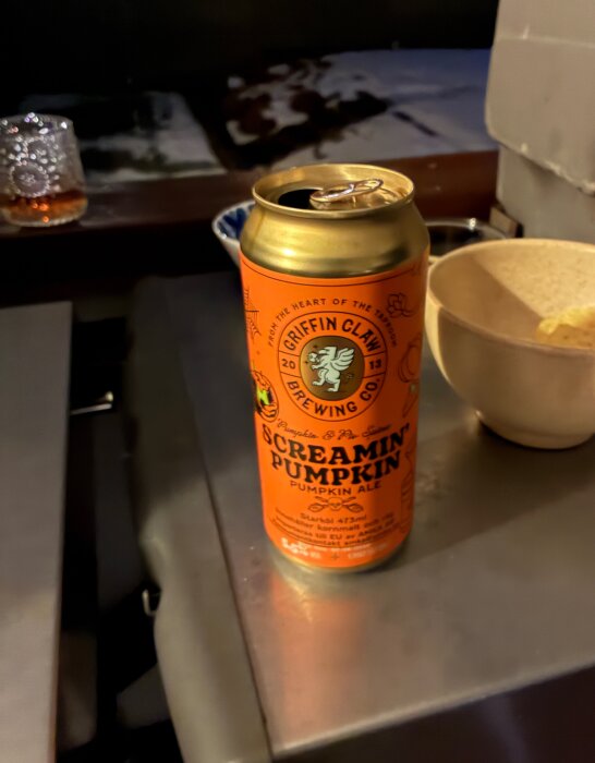 En burk Screamin Pumpkin ale står på ett bord bredvid en skål vid grillen.