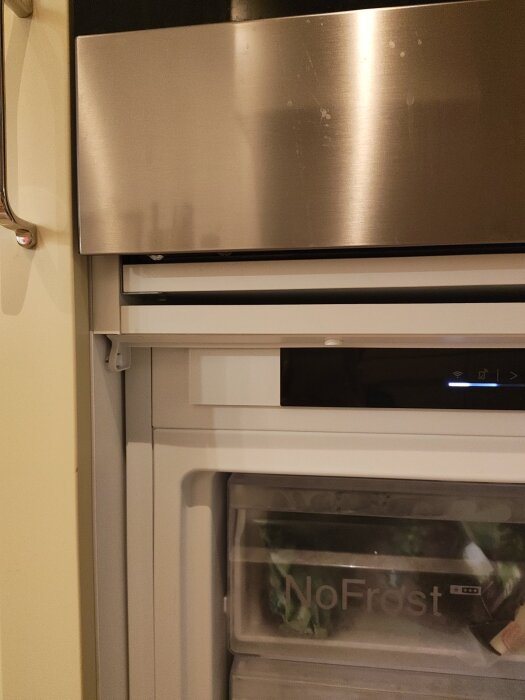 Modifierad IKEA-högskåpsstomme ovanpå Bosch-frys, visar skåpets nedre del och NoFrost-låda i frysen.