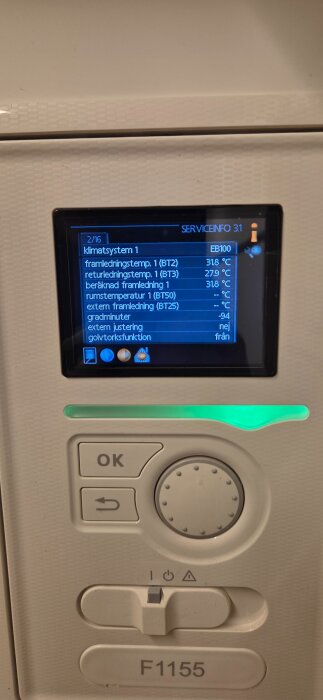 Närbild av paneldisplay och kontroller på en värmepump, visar temperaturinställningar och driftsinformation för klimatsystem 1, modell F1155.
