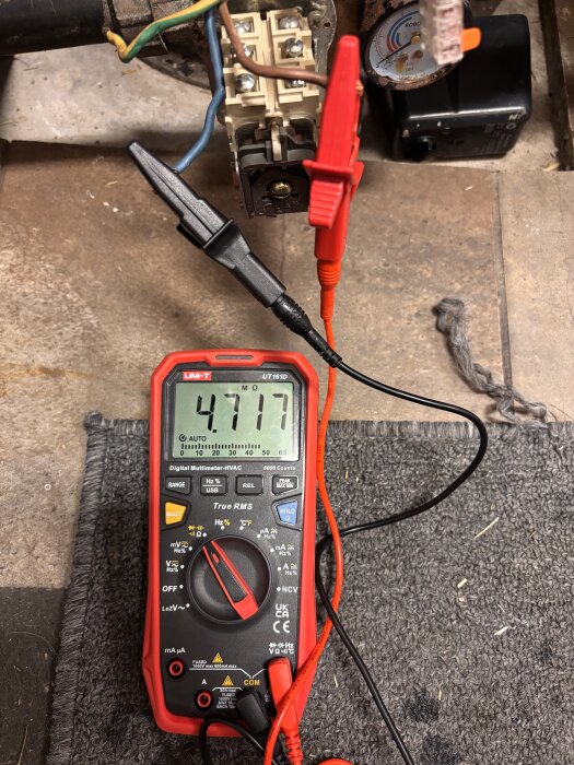 Multimeter visar 47,17 MΩ mellan kablar kopplade till pump, inspektion av eventuell felkälla.