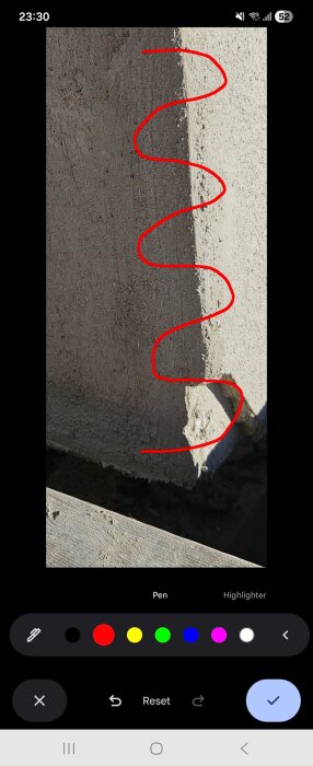 Vägg hörn med skadad puts, röd linje markerar området som ska repareras.