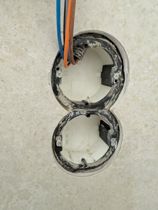Dubbel rot-dosa synlig i en vägg med installerade elledningar, märkt "RKE 06", för installation av brytare.