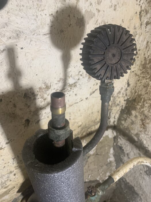 En tryckströmbrytare med en cylinderformad adapter och gängad koppling i ett hushållsrenoveringsprojekt.