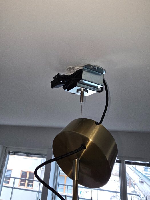 Takdosa med monterad IKEA Stockholm-lampa utan att borra, med synliga kablar och fäste i ett betongtak.