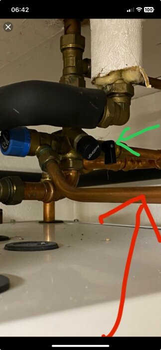 Vattenrör med ventil markerad av grön pil för påfyllning av systemet i ett byggprojekt.