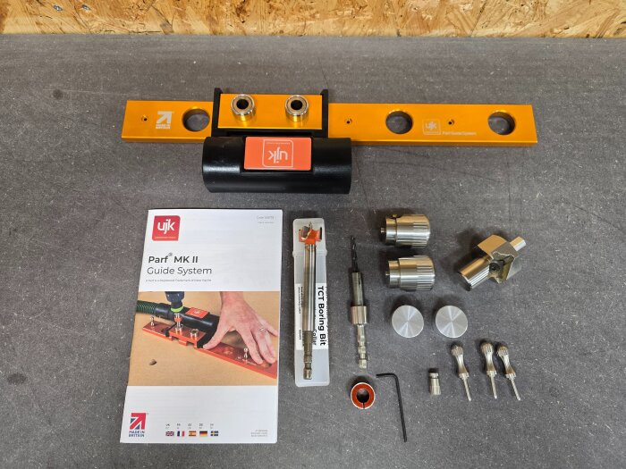 UJK Parf MK II Guide System med diverse tillbehör såsom borr och försänkare för 20 mm hål, inklusive manual, på ett bord.