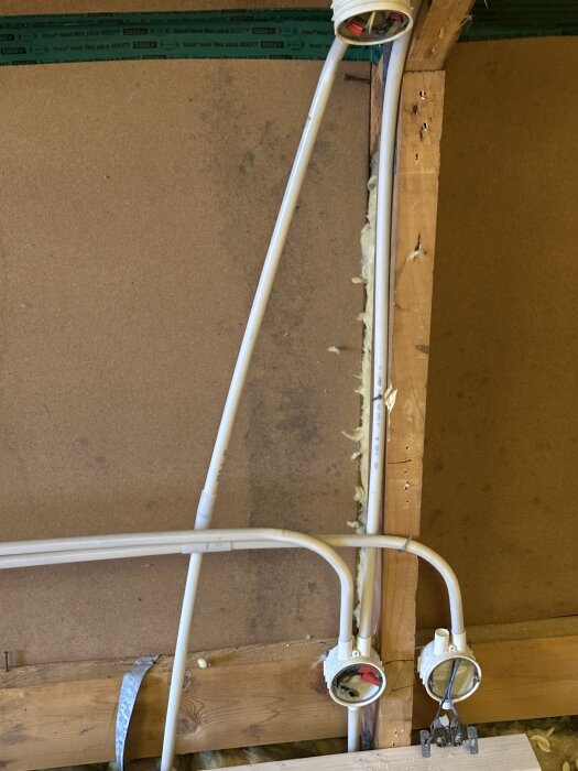 Masonitskivor med eventuella mögelfläckar, kablar och träreglar i ett renoveringsprojekt på översta våningen.
