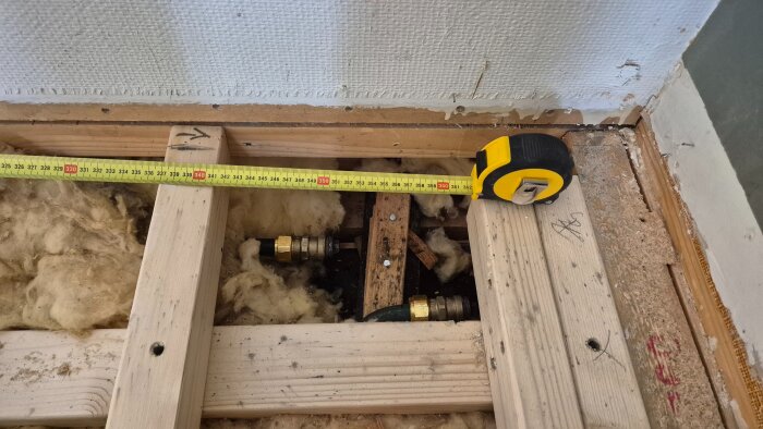 Mätband på 360 cm visar rörinstallation under trägolv med isolering. Allt ser torrt ut efter trycksättning.
