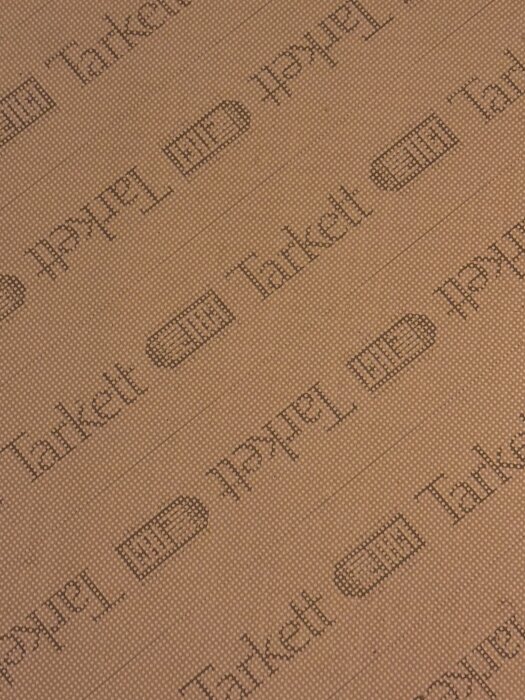 Plastmatta med text "Tarkett" upprepad diagonalt.