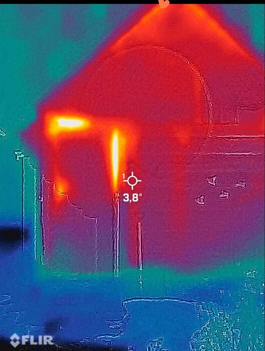Värmebild av isolerad bod med varma områden runt karm och dörr, visar potentiella glipor och värmeläckage. Tempmätning på 3,8 grader.