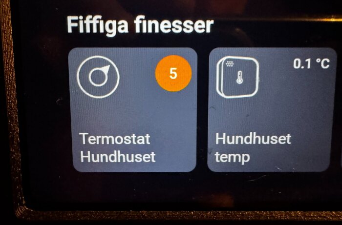 Bild av en digital skärm med appar som styr termostatfunktioner för ett hundhus och visar aktuell temperatur på 0,1 °C.