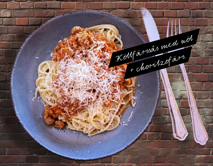 Spaghetti med köttfärssås av nöt- och chorizofärs, toppad med riven ost, serverad på en tallrik med bestick bredvid.