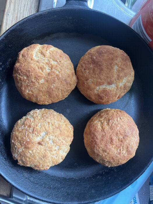 Fyra nybakade bröd i en gjutjärnspanna.