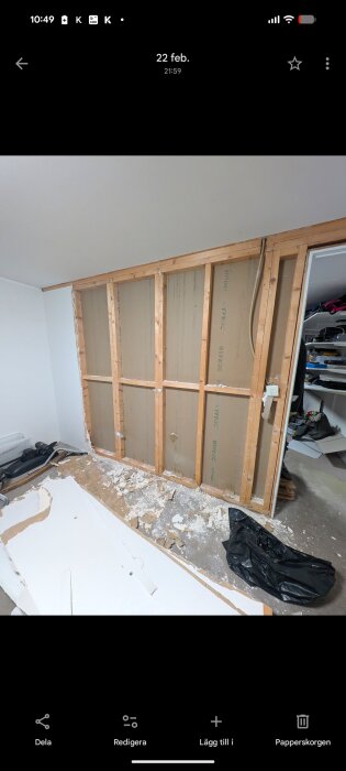 Riven vägg i garage, träreglar synliga och gipsskivor på golvet. Väggen verkar icke-bärande och har två reglar borttagna.
