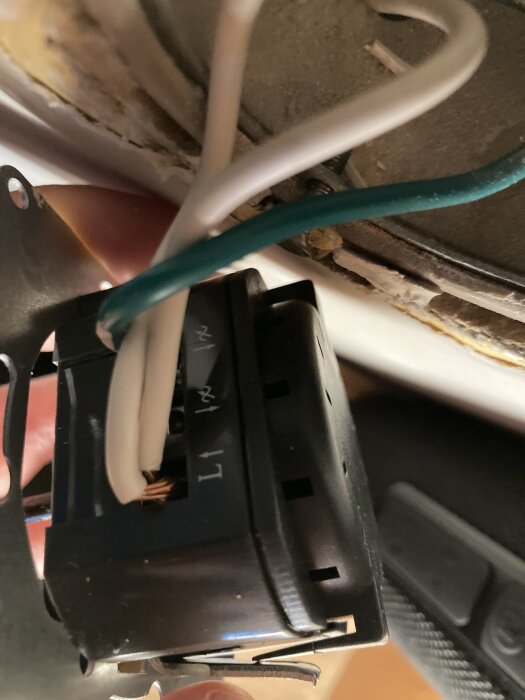 Inkopplad dimmer med två vita och en grön kabel anslutna, visar kontakter märka med L1 och symboler.