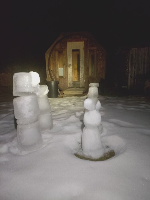 Bastutunna i snöig miljö med isblock och en snöfigur i förgrunden.