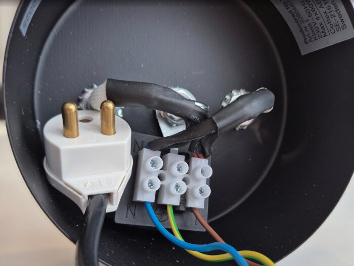 Kronuttag med kopplingsplint och insatta kablar, inklusive lampkontakt och ledningar i en lampa för att bedöma inkopplingens korrekthet.