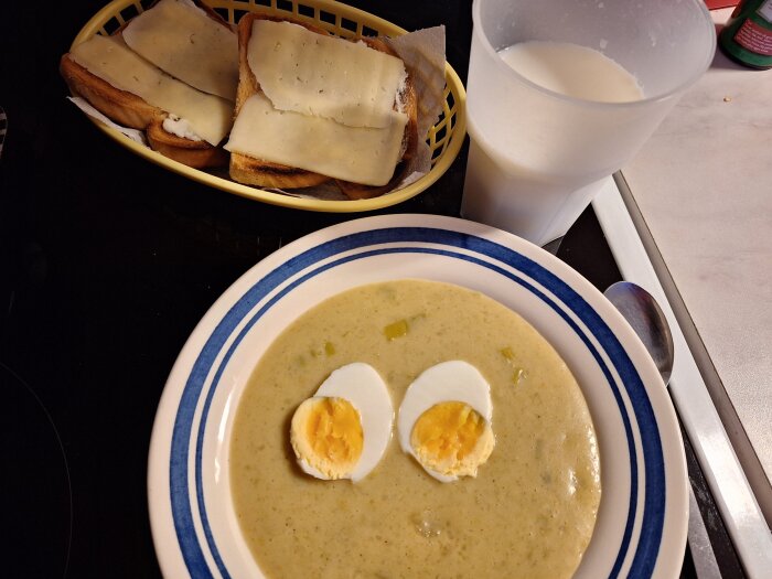 Potatis och purjolökssoppa med kokt ägg, rostade ostsmörgåsar och ett glas mjölk.