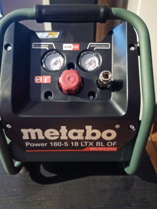 Batteridriven kompressor av märket Metabo med manometrar och tryckmätare, typ Power 160-5 18 LTX BL OF, anpassad för att förvaras i bilen.