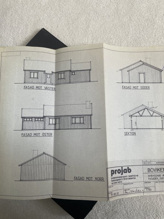 Gamla bygglovsritningar från 1979 med fasader och sektion av ett hus, inklusive väderstreck och detaljerad skala.