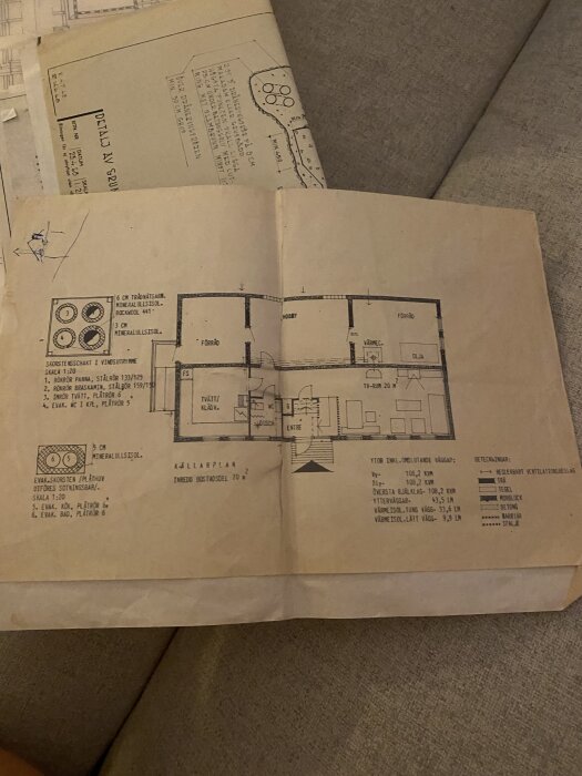 Gammal arkitektritning av Myresjöhus från 1969, med detaljerade planlösningar och rum beskrivna, liggandes på en soffa.