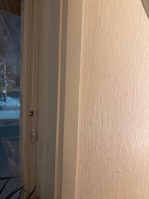 Fönsterkarm med vita foder i kvällsbelysning, frågeställning kring hur det kan lösas utan att ta bort befintliga foder.