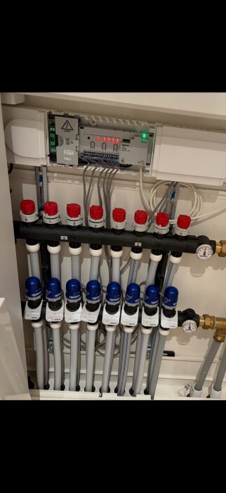 Distribution av golvvärme med Uponor-system och rör, uppkopplat till mätare och ventiler, del av värmesystem.