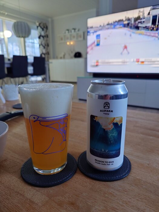 Ett glas öl och en burk Alefarm-bryggeri vid TV:n som visar ett längdåkningslopp.