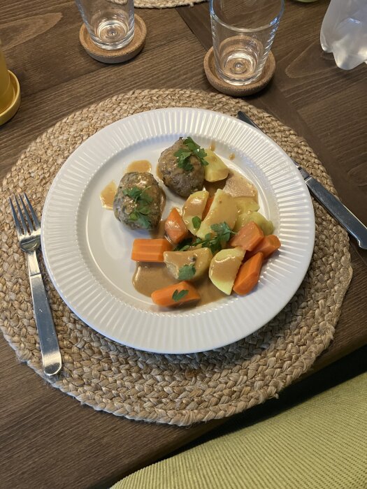 Persiljejärpar med grönpepparsås serverade med kokt potatis och morötter på vit tallrik.